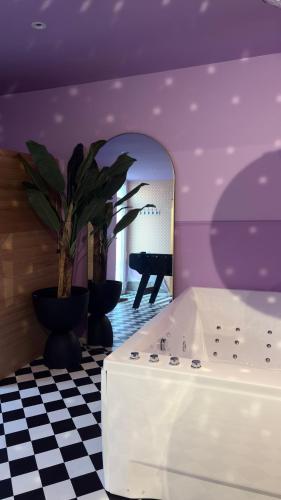 a room with a white tub and a mirror at My Funky House - Manage - Spa, jacuzzi, billard, cinéma, Nintendo Switch, karaoké in Manage