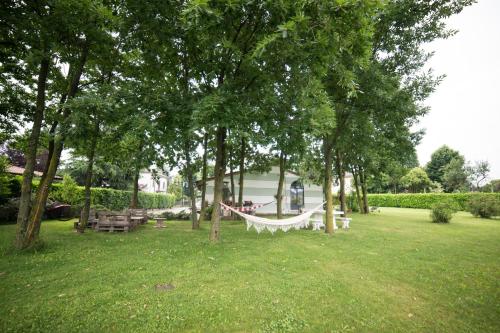 a hammock in a park with trees and benches at Villa Franca in Franciacorta in Passirano