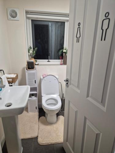 Houghton RegisにあるBazou Villaの白いトイレと洗面台のあるバスルーム