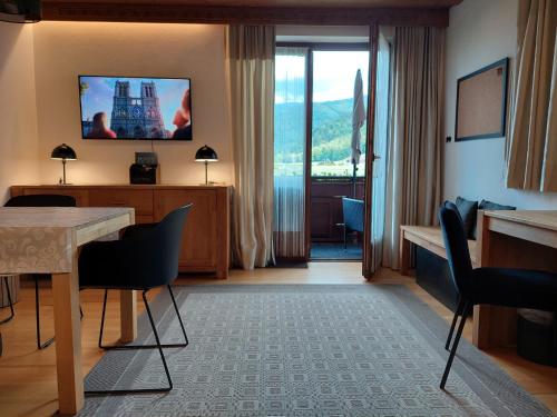 a hotel room with a table and a television on the wall at Apartment am Wolfgangsee in Strobl