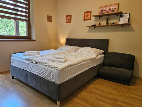 a bedroom with a large bed and a chair at Fatrapark 1 Apartments in Ružomberok
