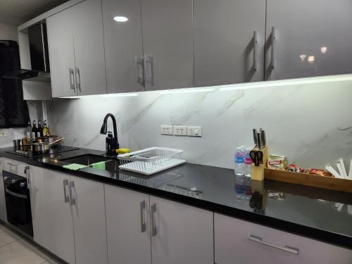 a kitchen with white cabinets and a black counter top at Kandi Suites 2BR with private Jacuzzi 500 Mbps internet in Angeles