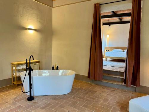 a bathroom with a bath tub and a bed at The Monteleone Umbria Retreat in Monteleone dʼOrvieto
