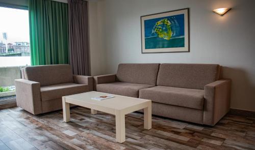a living room with two couches and a coffee table at Hotel Palacio del Mar in Santander