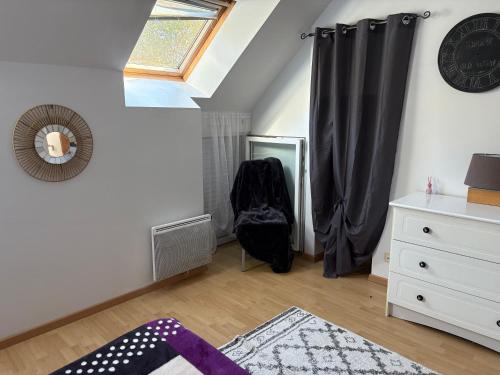 a bedroom with a window and a dresser and a mirror at Location de vacances brocéliandes in Maxent