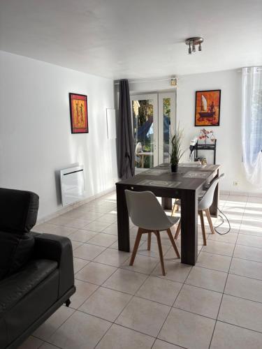 a living room with a black table and chairs at Location de vacances brocéliandes in Maxent