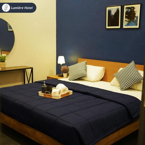 a bedroom with a large bed with blue sheets and pillows at Lumière Hotel Islamabad in Islamabad