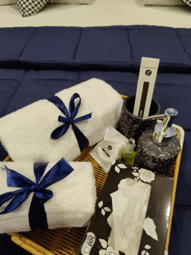 a basket of towels with blue bows on a bed at Lumière Hotel Islamabad in Islamabad