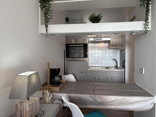 a kitchen with a table and a kitchen with a sink at Berolina 119 - Alte Liebe in Dahme