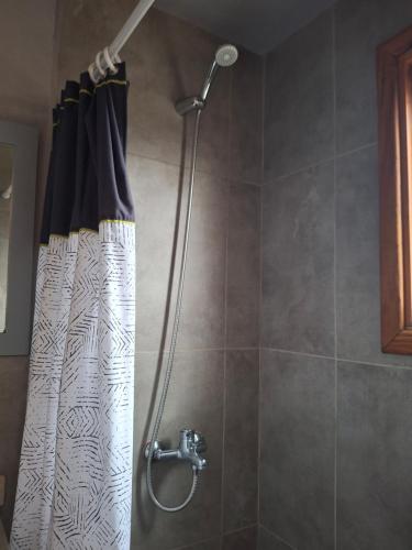 a shower with a shower curtain in a bathroom at Cabañas Bella vista Ruca hue in San Martín de los Andes