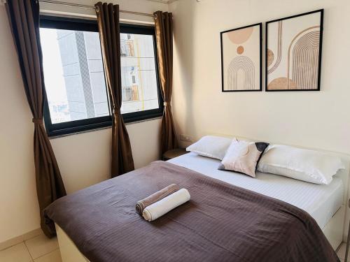a bedroom with a bed with two towels on it at AquaPrivate 1Bhk Apartment in Amanora Park Town in Pune