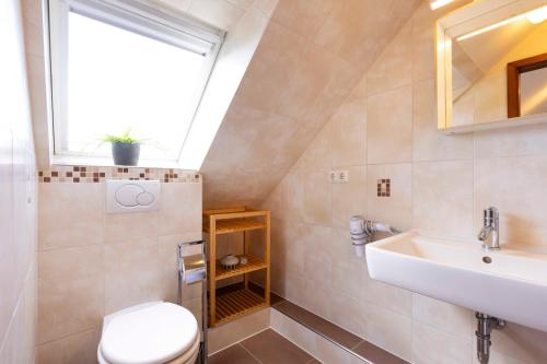 a bathroom with a sink and a toilet and a window at MEI27a Ferienwohnung Ostseetraum in Niendorf