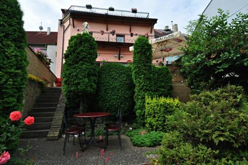 a table in a garden in front of a building at Hotel Na Hradbách in Louny