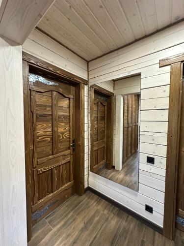 an empty room with wooden doors and wooden floors at Біля Плаю in Plav'ya