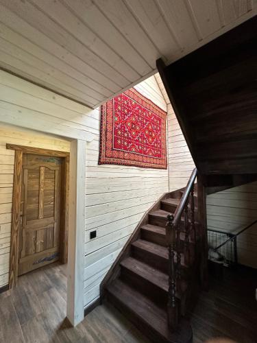a staircase in a house with a rug on the wall at Біля Плаю in Plav'ya