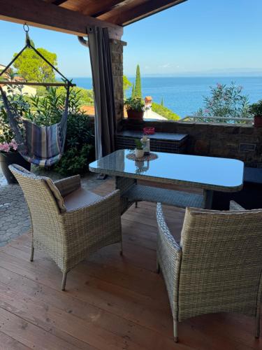 a table and chairs on a patio with a view of the ocean at Apartment Emma in Piran