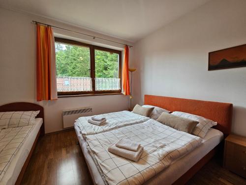 a bedroom with two beds and a window at Fatrapark 1 Apartments in Ružomberok