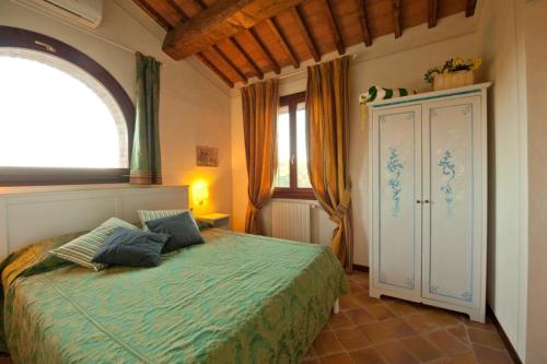 um quarto com uma cama e uma grande janela em Podere Chiaromonte em Palaia