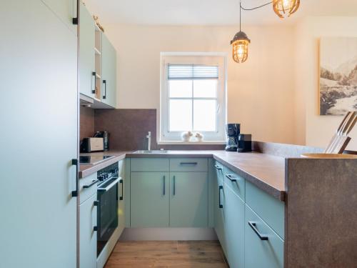 a kitchen with blue cabinets and a window at Chalet in Krimml near Ski Slopes in Krimml