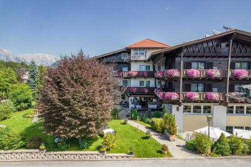 an apartment building with a tree in front of it at Parkhotel Seefeld in Seefeld in Tirol