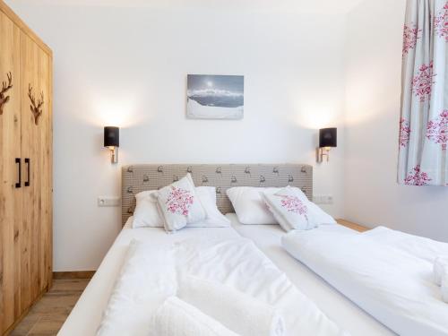 two beds in a bedroom with white sheets and pillows at Chalet in Krimml near Ski Slopes in Krimml