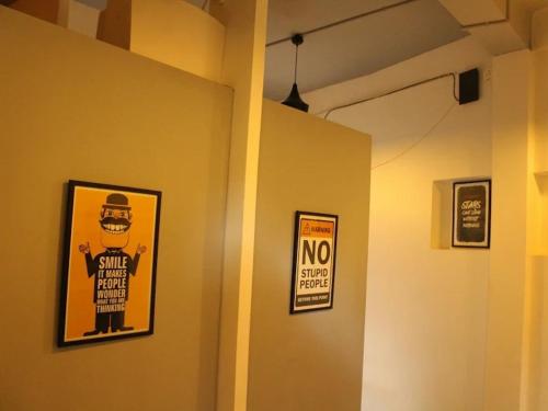 a room with two posters on the wall and a no smoking sign at Seeya Heritage Hostels in North goa