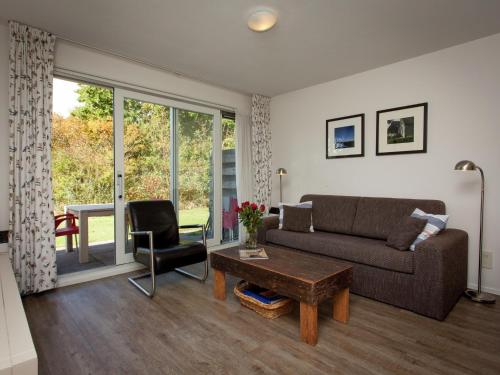 a living room with a couch and a table at Apartment in Hollum near the Sea in Hollum