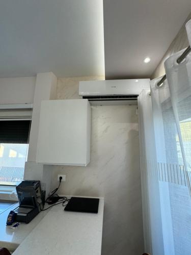 a kitchen with a white cabinet and a microwave at Sea View Deluxe Apartments Qerret Golem in Kavajë