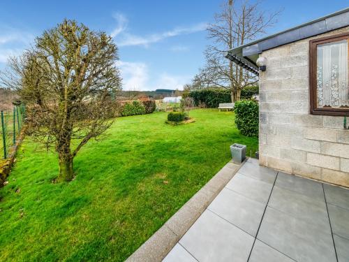 a backyard with a grass yard and a building at Modern Holiday Home in Lavacherie in Sainte-Ode