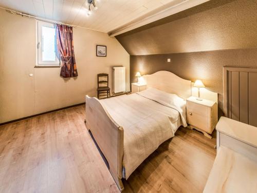 a bedroom with a large bed and a window at Modern Holiday Home in Lavacherie in Sainte-Ode