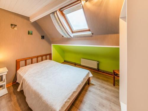 a bedroom with a bed and a green wall at Modern Holiday Home in Lavacherie in Sainte-Ode