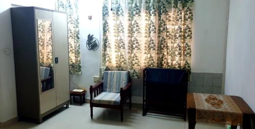 a room with two chairs and a table and a curtain at The Colombo Grid in Colombo