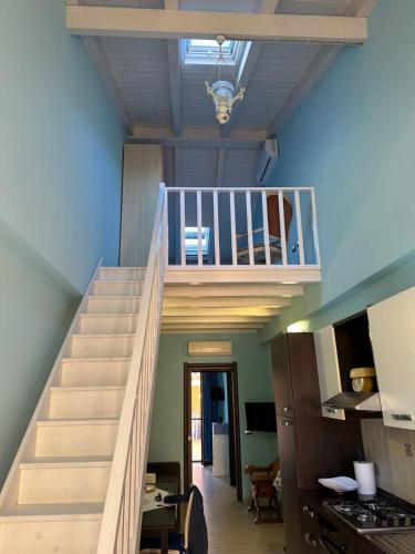 a staircase leading up to a kitchen with a stair case at Via Roma House Casetta in Terralba
