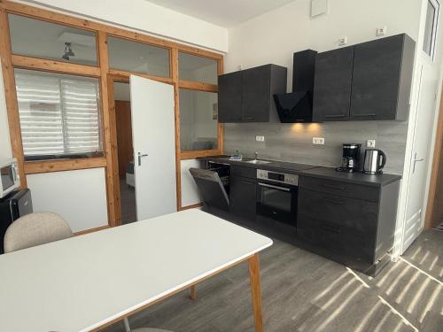 a kitchen with black cabinets and a white table at Haus Burmeister in Sassnitz
