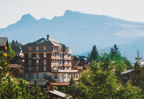 a large building on the side of a mountain at Hotel Regina in Mürren