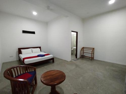 a bedroom with a bed and a table and a chair at Savendro Villa Hikkaduwa in Hikkaduwa