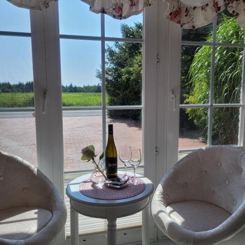 a table with a bottle of wine and two chairs at Strandmuschel in Aventoft