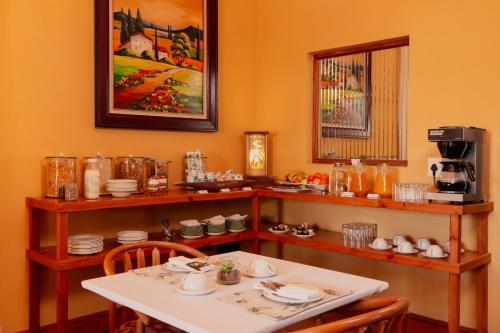a dining room with a table and a coffee maker at 88 Baron van Reede Guesthouse in Oudtshoorn