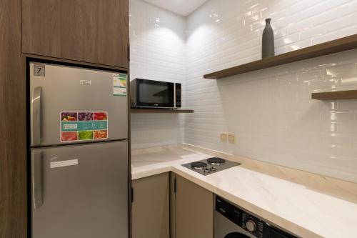 a kitchen with a refrigerator and a microwave at فندق لوكسري سويتس- Luxury Suites Hotel in Taif