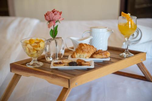 a wooden table with a tray of pastries and drinks at Lakala Complexe Touristique in O Ben Slimane