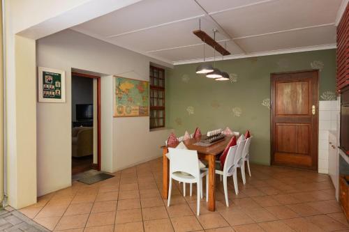 a dining room with a table and white chairs at 88 Baron van Reede Guesthouse in Oudtshoorn