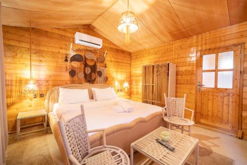 a bedroom with a bed in a wooden room at Lakala Complexe Touristique in O Ben Slimane