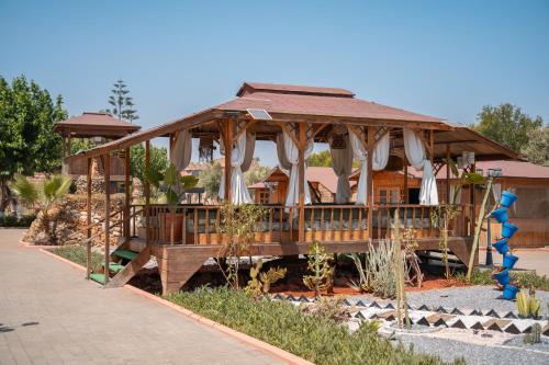 a building with a gazebo in a garden at Lakala Complexe Touristique in O Ben Slimane