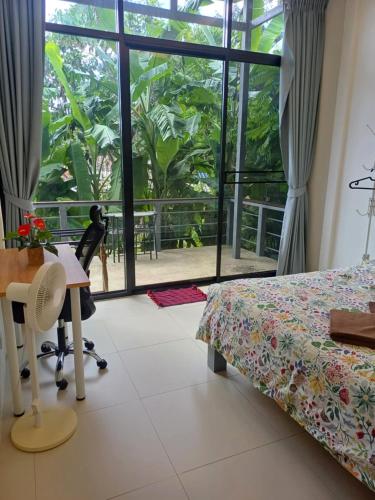 a bedroom with a bed and a desk and a window at Modern Bungalows in Ko Chang