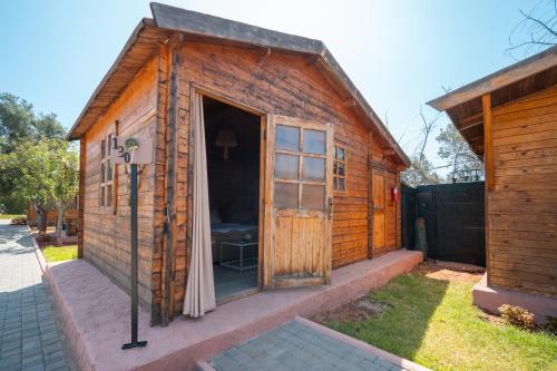 a small wooden building with a door in a yard at Lakala Complexe Touristique in O Ben Slimane