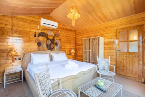 a bedroom with a bed and chairs in a cabin at Lakala Complexe Touristique in O Ben Slimane