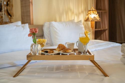 a tray with food and drinks on a bed at Lakala Complexe Touristique in O Ben Slimane