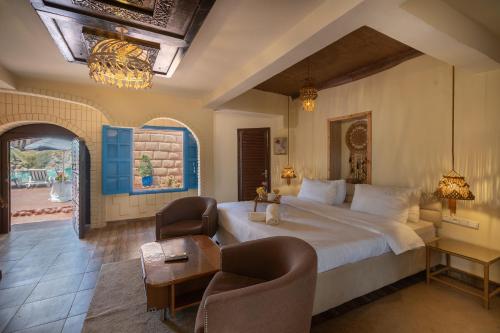 a bedroom with a large bed and two chairs at Lakala Complexe Touristique in O Ben Slimane