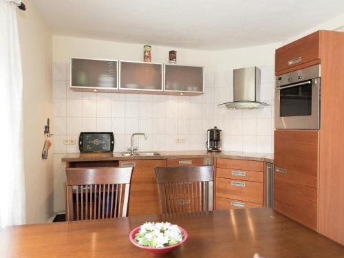 a kitchen with a wooden table with a bowl of flowers at Grand Getaway in Deutschneudorf in Deutschneudorf