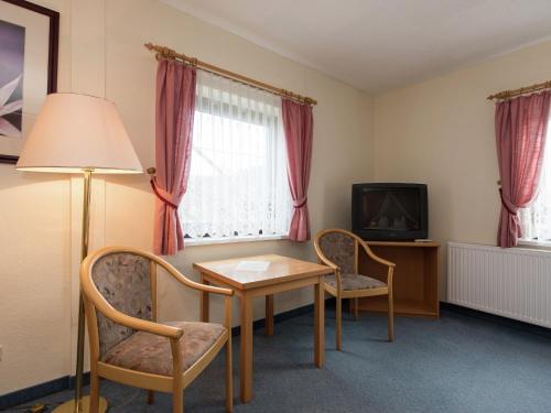a room with a table and chairs and a television at Grand Getaway in Deutschneudorf in Deutschneudorf